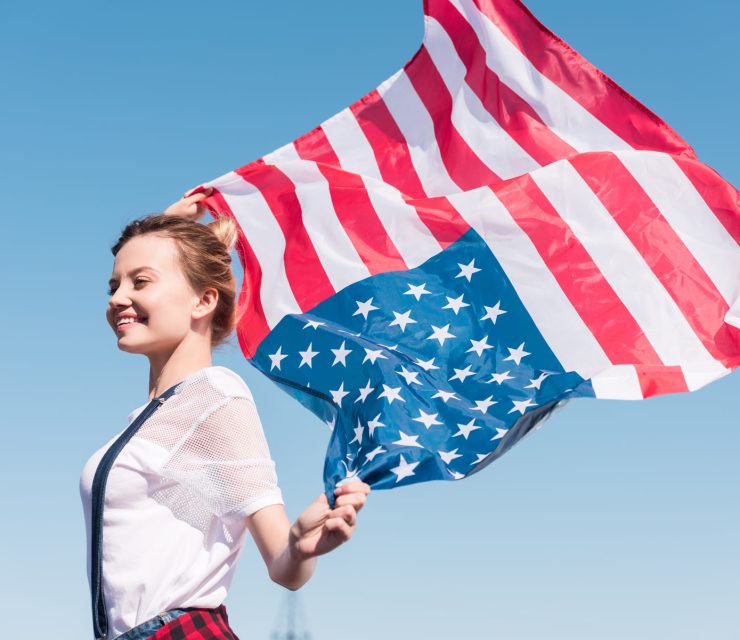 happy-young-woman-holding-united-states-flag-again-BESAKW2.jpg